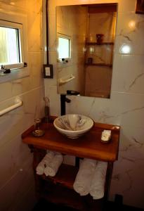 un bagno con lavandino e specchio di Cabaña La Marilena, para 2 huespedes con desayuno a El Calafate Altre 27 foto