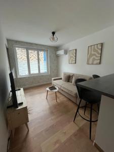 a living room with a couch and a tv at Playa Del Sol Moderne Clim Vélo in Sainte-Marie-la-Mer +28 photos