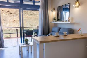 a living room with a table and a large window at Casa Guillaume in Mogán