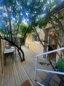 a room with a tree on a wooden deck at Studio Terrasse Le petit cabanon in Serres +7 photos