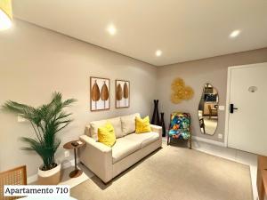 a living room with a white couch and a plant at Book Santos - Estanconfor 710 e Estanconfor 810 Apto Executivo in Santos