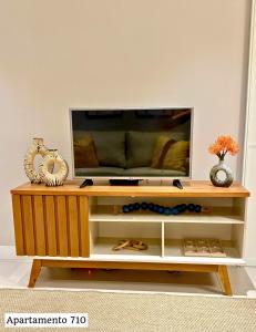 a tv on a wooden entertainment center with a television at Book Santos - Estanconfor 710 e Estanconfor 810 Apto Executivo in Santos