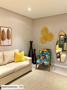 a living room with a couch and a chair and a mirror at Book Santos - Estanconfor 710 e Estanconfor 810 Apto Executivo in Santos