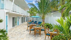 a patio with tables and chairs and palm trees at Sea Dream - Pet Friendly, Located in Siesta Key Village, Steps to Siesta Key Beach! in Bailey Hall