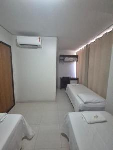 a room with two beds and a heater in it at Hotel Capelari in Nova Mutum +1 photo