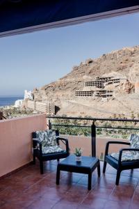 a balcony with chairs and a table and a view at Casa Guillaume in Mogán