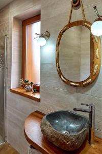 a bathroom with a stone sink and a mirror at Casa Rural Cuenca Bucer in Ormas