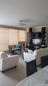 a living room with white furniture and a flat screen tv at Chipipe Riviera del Mar in Salinas
