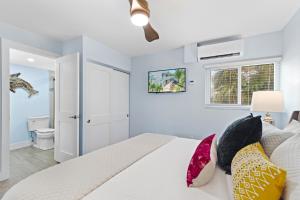 Bailey HallにあるSea Coast - Pet Friendly, Located in Siesta Key Village, Steps to Siesta Key Beach!の白いベッドとカラフルな枕のある寝室