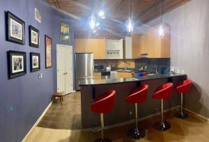 a kitchen with red bar stools and a counter at Washington Loft in Saint Louis