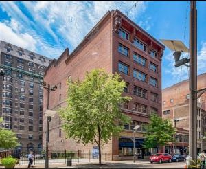 a large brick building with a tree in front of it at Washington Loft in Saint Louis