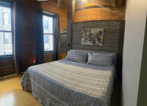 a bedroom with a bed in a room with windows at Washington Loft in Saint Louis