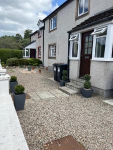 a house with a gravel yard in front of it at Two bedroom apartment Culloden Inverness Highlands in Culloden
