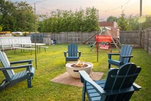 three chairs and a fire pit in a yard with a playground at Heated Pool, Hot Tub, Walk to Town, Games! in South Haven