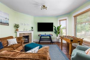 a living room with a couch and a table at Heated Pool, Hot Tub, Walk to Town, Games! in South Haven