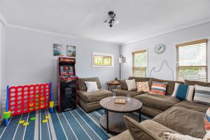 a living room with a couch and a table at Heated Pool, Hot Tub, Walk to Town, Games! in South Haven