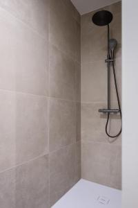 a bathroom with a shower with a shower head at Madame Sardine in Ostend