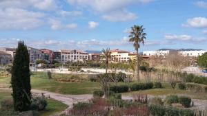 Blick auf ein Resort mit Palmen und Gebäuden in der Unterkunft Golfe de saint-tropez a 50 m de la plage in Gassin