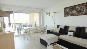 ein Wohnzimmer mit Sofa und Tisch in der Unterkunft Golfe de saint-tropez a 50 m de la plage in Gassin