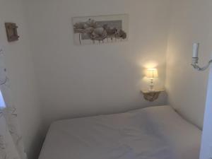 ein kleines Schlafzimmer mit einem Bett und einer Lampe in der Unterkunft Golfe de saint-tropez a 50 m de la plage in Gassin