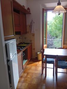 a kitchen with a table and a dining room at Casa Rita in Lizzano in Belvedere +3 photos