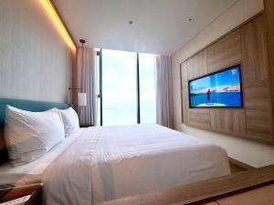 下龙湾à la carte halong bay hotel的一间配有大床和平板电视的卧室