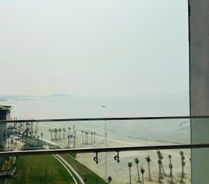 下龙湾à la carte halong bay hotel的从棕榈树海滩的窗户欣赏美景