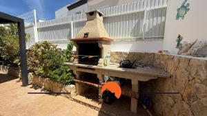 a outdoor kitchen with a pizza oven on a patio at #343 Villa with Pool & Jacuzzi by Home Holidays in Vale de Pedras
