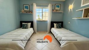 two beds sitting in a room with a window at #343 Villa with Pool & Jacuzzi by Home Holidays in Vale de Pedras