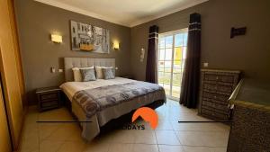 a bedroom with a bed and a large window at #343 Villa with Pool & Jacuzzi by Home Holidays in Vale de Pedras