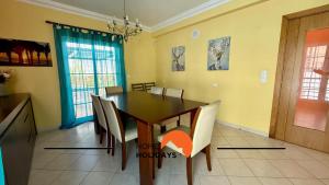 a dining room with a wooden table and chairs at #343 Villa with Pool & Jacuzzi by Home Holidays in Vale de Pedras