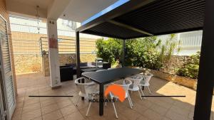 Un patio con una mesa y sillas en un patio. en #343 Villa with Pool & Jacuzzi by Home Holidays, en Vale de Pedras