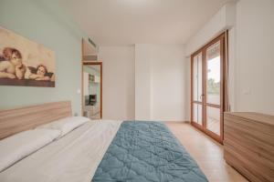 a white bedroom with a large bed and a window at Viky Flat - 15 min from Venice & Free Parking in Venice
