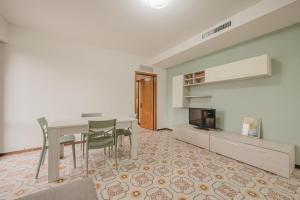 a living room with a table and chairs and a tv at Viky Flat - 15 min from Venice & Free Parking in Venice