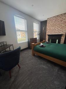 a bedroom with a green bed and a fireplace at City Centre Chic in Bangor