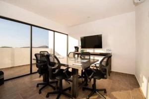 a room with a table with chairs and a television at Marina Cerritos Mazatlan in La Florida