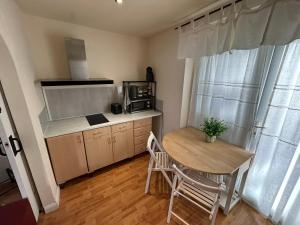 a small kitchen with a wooden table and a table and chairs at The Shaw House, 2 in Knutsford