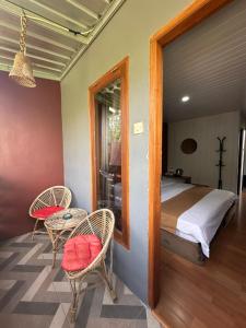 a bedroom with a bed and two chairs and a table at Istana Bromo Resort in Bromo +78 photos
