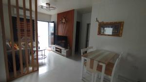 a living room with a table and a television at Danielle's Haven in Naga