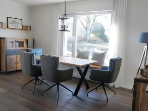 Un comedor con mesa y sillas de madera. en Ferienwohnung Jost, en Allendorf