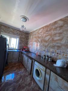 a kitchen with a washing machine in a counter at Oasis Privado Castillejos in Riffiene +13 photos