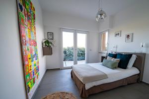 a bedroom with a bed and a large window at magnifique maison vu mer 5 ch in Porto-Vecchio