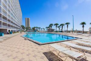 a swimming pool with lounge chairs and a building at Summit 803 - Luxury Beach Resort Condo 1-6 People in Panama City Beach