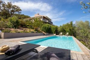 a swimming pool with a table and a house at magnifique maison vu mer 5 ch in Porto-Vecchio