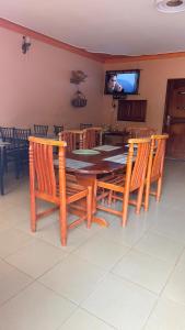 a dining room with a table and chairs and a television at Highland hotel kapchorwa in Kapchorwa