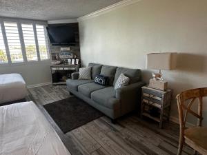 a living room with a couch and a tv at Renovated Beach Front Condo - Top Of The Gulf 302 in Panama City Beach