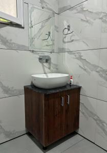 a bathroom with a sink and a mirror at Tapovan 1 BHK I Rivara I Ganga I High Speed Wifi in Rishīkesh +5 photos