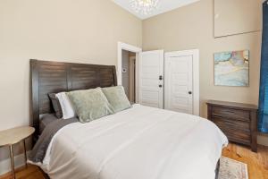 a bedroom with a large white bed with a wooden headboard at 1 Bedroom Home in Downtown Lake Charles La in Lake Charles