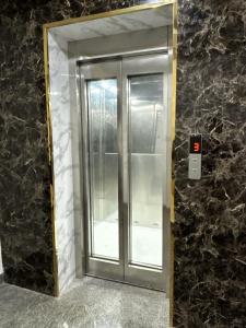 a glass elevator door in a stone wall at Tapovan 1 BHK I Rivara I Ganga I High Speed Wifi in Rishīkesh