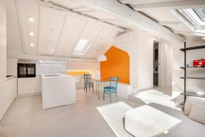 een keuken en woonkamer met een tafel en stoelen bij La Mansarda di Via Niella in Savona